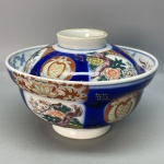 PORCELANA - Linda tigela em porcelana com tampa, decorada de branco e azul, flores policromadas. Med. 11x16 cm.