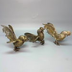 METAL - Trio de galos de briga em bronze espessurados a prata. Med. 10 cm. Um com asa quebrada.