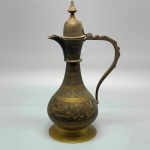 METAL - Belo jarrinho de metal dourado de origem árabe, lavrado e cinzelado. Alt. 22 cm. Marcas do tempo e de uso.