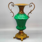 CERÂMICA - Vaso floreira em cerâmica vitrificada com base em bronze, anjos, alças e parte superior em metal dourado. Med. 35x24x14 cm.