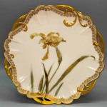 PORCELANA - Prato decorativo em porcelana francesa, LIMOGES, decorada com flores policromadas, borda vazada e ricamente dourado. Dia. 23 cm.