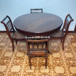 MOBILIÀRIO - Antiga mesa de jantar redonda, elástica com 4 cadeiras, tampo folhado com faltas, cadeiras torneadas, assento em palhinha natural. Med. fechada 80x110 cm e aberta 80x158x110 cm e cadeira85x41x45 cm. Móveis Usados - Lote de móvel antigo e usado, podendo apresentar marcas de uso e desgaste natural do tempo. Há possibilidade de danos ocultos e ou outras imperfeições.  Não há garantia ou possibilidade de devolução após a aquisição. Recomenda-se inspeção prévia.