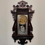 RELÓGIO - Relógio de parede da marca "Ansonia". Caixa em madeira nobre entalhada com florão em formato de concha. Vidro da porta em pintura jateada. E.U.A. Med. 73x35x10 cm. Com chave e pêndulo.  Não testado e sem garantia.