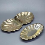 METAL - Lote de 2 petisqueiras em metal espessuradas a prata em formato de concha. Med. 18x10 cm e 27x13 cm. Desgastes.