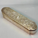 METAL - Antiga caixa em metal espessurado a prata, tempa ricamente trabalhada em relevo, arabescos e motivos florais. Med. 4x21x5 cm.