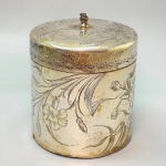 METAL - Porta chá em metal espessurado a prata, ricamente lavrado com motivos vegetalistas, pegador com falta, base em madeira. Med. 11x8,5 cm.