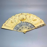 COLECIONISMO - Antigo leque em marfim, ricamente decorado com incrustrações em prata, delicadas folhas em seda, decorada ao centro com cesto de fruta policromado. Med. fechado 30 cm. Desgastes e pequenas faltas.