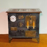 MOBILIÁRIO - Antigo fogão a lenha com estrutura em ferro em preto, composto por grelha com seis bocas em ferro fundido, corpo retangular com portas e gavetas adornadas com pegas apliques em bronze. Placa esmaltada "Fundição São Pedro". Med. 77x79x60 cm. Marcas do tempo e de uso. Utilizado por décadas apenas como decoração. Móveis Usados - Lote de móvel antigo e usado, podendo apresentar marcas de uso e desgaste natural do tempo. Há possibilidade de danos ocultos e ou outras imperfeições.  Não há garantia ou possibilidade de devolução após a aquisição. Recomenda-se inspeção prévia.