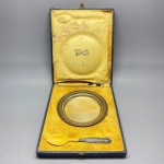 METAL - Conjunto infantil, composto de prato e colher. Prato e cabo em metal espessurado a prata. Acompanha estojo. Marcas do tempo e de uso.