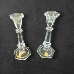 Par de castiçais para uma vela em cristal translúcido by La Vida,  base e bordas da bobeche sextavadas, Alt. 20, Diam. 5 e 8 cm.