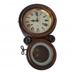 Relógio oito, 30 dias em caixa de madeira nobre, algarismos romanos, em caixa metálica com bordas em metal dourado e com a chave de corda, com proteção de vidro e parte inferior com frisos brancos, funcionando, Com. 44,  Diam. 26 e 17, Prof. 11 cm. cm.