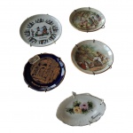 COLECIONISMO - Cinco pratinhos em porcelana europeia, policromados, o austríaco com lascado na borda, Diam. 8,5 cm.