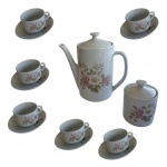 Aparelho para chá em porcelana Pozzani decorado com singelas flores sobre fundo branco, composto de 1 bule, 1 açucareiro e 8 xícaras para chá com pires, em sua embalagem original, nunca foi usado, bule 18 x 11 cm.
