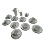 Guarnição para chá em porcelana Renner decoração de flores e frisos dourados sobre fundo branco composto de: 9 xícaras, (1 bicada e outra bem danificada na parte externa da base), com pires, (1 bicado) 9 pratos para sobremesa, (2 bicados)1 bule sem a tampa, 1 cremeira e 1 açucareiro, (com bicado na borda), Total: 21 peças.