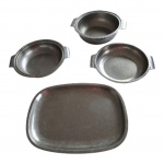 Quatro travessas em inox, Diam. 21 e 23 cm. e 34 x 25 cm.