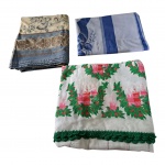 Três toalhas de mesa, uma delas com bainha em bilro e motivos natalinos,  todas com leves marcas de guarda, Natalina: 228 x 146 cm.  estampa azul: 140 x 140 e estampado em fundo amarelo 220 x 140 cm.