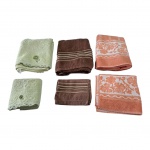 Três jogos de tolhas banho e rosto, a marrom com bastante marcas de uso.