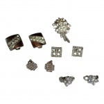 Quatro pares de brincos e um broche em metal prateados e pedras `brilhantes` translúcidas.