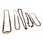 Cinco colares em materiais e modelos  diversos.