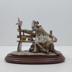 Enfeite  Decoração, Escultura Estilo Capo di Monte em Resina e Base em Madeira,  Andarilho alimentando uma Pomba, Necessita restauro, no encosto do banco, está solto. Medidas: Altura: 20,5 cm, Largura: 14,5 cm, Comprimento: 28,5 cm, Peso: 1310 g.