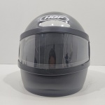 Capacete de Motociclista, Marca HGF, Modelo T, Tamanho 58, Com Trincados na Viseira. Medidas: Altura: 25 cm, Largura: 33,5 cm, Comprimento: 27 cm, Peso: 1200 g.