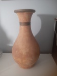 Belo jarro, provavelmente em terracota, moderno e sofisticado com design clássico. Ideal para complementar qualquer decoração, uma peça de destaque para seu ambiente. Altura: 44 cm