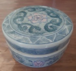 Antigo Porta-Jóias em porcelana, uma peça refinada que exibe a beleza de desenhos em arabescos, flores em tom de rosa e em uma paleta sofisticada de tons de azul. Este porta-jóias é uma verdadeira jóia de coleção, refletindo a riqueza da arte e o estilo atemporal. Diâmetro: 13 cm e Altura: 7 cm