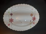 Travessa em porcelana branca com bordas onduladas e um delicado acabamento decorativo com flores , com o mesmo design refinado e bordas onduladas com estilo clássico, com um toque elegante, ideal para ocasiões especiais ou para dar um ar sofisticado às refeições do dia a dia. - Medidas: