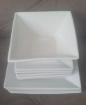 Pratos brancos quadrados  de sobremesa e pires , feitos em cerâmica , com design moderno e com um bowl.