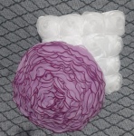 Duas almofadas com formato de flor na cor rosa, e outra branca com flores, confeccionada em tecido e outra em organza. A textura delicada e o brilho, combinado com o design floral em tom rosa, proporcionam um toque de elegância e charme ao ambiente. Ideal para adicionar um detalhe sofisticado e encantador à sua decoração. -Diâmetro: 40 cm e 38x38 cm