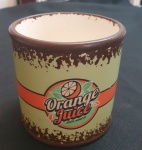 Pote cilíndrico em louça , estilo retrô, com estampa Orange Juice  100% natural em faixa laranja sobre fundo verde-claro. Interior branco e detalhes em marrom nas bordas, com efeito de desgaste decorativo. Peça decorativa e multiuso. - Altura: 10 cm e Diâmetro: 10 cm