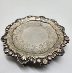 Salva em prata portuguesa, marca L.J.F., contraste P coroado (Porto, prata 925), Salva circular com borda recortada e repuxada em ornamentação floral e rocalhas, de inspiração rococó. Peça apoiada sobre três pés fundidos em forma de garras sobre esfera, elegantemente modelados, típicos da tradição neoclássica. Centro gravado com arabescos e folhagens em cinzelado fino. Punções: P coroado (contraste da cidade do Porto, prata 925) e L.J.F. (marca do ourives). Diâmetro: 18 centímetros. Peso:197 gramas.