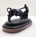 Imponente escultura em bronze patinado, assinada Andrés Peralta e numerada 184/1299, representando toureiro e touro em pleno embate  composição dinâmica de grande vigor plástico e expressividade dramática. A modelagem revela o domínio característico de Andrés Peralta, escultor espanhol ativo na segunda metade do século XX, conhecido por suas figuras realistas e composições tensas que exploram o movimento e a anatomia com refinamento técnico. A obra se destaca pela pátina castanha escura com nuances verdes, e pela força gestual com que o artista captura o instante de confronto e harmonia entre homem e animal  símbolo da tradição taurina ibérica. Fundida em bronze de alta densidade, provavelmente pelo método de cera perdida, e montada sobre base em madeira polida, apresenta acabamento manual minucioso. Peça assinada na base e na obra. Dimensões:14 x 21 x 11.