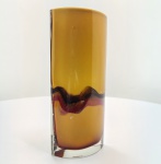 Vaso em vidro Murano, de forma retangular  arqueada, executado em tonalidade âmbar translúcido com faixa ondulada interna em matizes vinho, rubi e negro, criando um efeito fluido e pictórico. A pureza das linhas e a espessura do vidro denotam execução de ateliê, com excelente controle técnico e composição cromática. Peça de presença contemporânea e elegante, ideal para compor ambientes modernos ou coleções de vidro de arte do século XX. Dimensões: 27 x 11 x 7 centímetros.