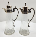 Magnífico par de decantadores em cristal Baccarat. Peças lapidadas com maestria, adornadas com gargalos e alças em prata portuguesa maciça, contrastadas com o punção prata javali, instituído em 1887 para certificar prata de 1º título (916). As monturas, de elegante estilo neoclássico, apresentam volutas, folhas de acanto e cinzelado minucioso, revelando o refinamento técnico das oficinas portuguesas do período. A união entre a transparência pura do cristal Baccarat e o brilho cálido da prata portuguesa cria um conjunto de rara harmonia e prestígio. Dimensões: 32 x 14 x 10 centímetros.