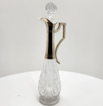 Elegante licoreira de fabricação WMF  Württembergische Metal lwarenfabrik, Alemanha, circa 1925, período de transição entre o final do Jugendstil e o início do Art Déco europeu. O corpo em cristal lapidado de alta transparência apresenta complexa lapidação em painéis geométricos e rosetas em relevo, refletindo o gosto pelo rigor e pela simetria típicos do Art Déco. A gola e a alça, executadas em metal prateado WMF (punção I/O), exibem linhas retas e angulares, de composição arquitetônica, com o bico projetado em leve curva  combinação de funcionalidade e design refinado .Na gola, punções WMF: avestruz em losango (marca da manufatura) e I/O, indicando espessura superior de banho de prata. Tampa original em cristal lapidado esférico, perfeitamente ajustada ao gargalo. Dimensões: ( 35 x 14 centímetros )