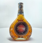 Johnnie Walker Swing  Blended Scotch Whisky (750 ml / 40% vol. Criado por Sir Alexander Walker II, neto do fundador John Walker, o Johnnie Walker Swing é um blend premium composto por cerca de 35 whiskies, com predominância de maltes envelhecidos das regiões de Speyside e Highlands. Apresenta coloração âmbar dourada e aromas ricos de mel, frutas secas, baunilha e especiarias suaves. No paladar, é encorpado e sedoso, com equilíbrio entre notas doces e defumadas, final longo e refinado  fiel à tradição escocesa da casa Walker.A garrafa, de design exclusivo e base curva, confere elegância e movimento à apresentação, sendo um destaque tanto em bares sofisticados quanto em coleções de whiskies vintage. Origem: Escócia Produtor: John Walker & Sons Ltd. Criação: Década de 1930Volume: 750 ml Graduação alcoólica: 40%Categoria: Blended Scotch Whisky  Edição Premium