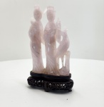 Escultura chinesa em quartzo rosa natural, representando duas figuras femininas, apoiada em base original de madeira entalhada. Peça trabalhada em quartzo rosa translúcido, com veios internos naturais. As duas figuras femininas aparecem lado a lado, com vestes fluídas e atitude serena, seguindo temas tradicionais da arte chinesa ligados à beleza, harmonia e boa fortuna. A base em madeira escura é inteiramente entalhada à mão no estilo chinês clássico, com recortes e motivos vazados (pierced carving). O pedestal apresenta curvas suaves, bom acabamento e encaixe estável, evidenciando fabricação contemporânea à escultura e integridade do conjunto. Dimensões: 20x12x6 centímetros. Apresenta pequenos desgastes e perdas em pontas mais delicadas, comuns em esculturas de pedra.