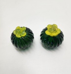 Conjunto decorativo composto por duas peças em vidro artístico soprado, modeladas em formato de pequenas frutas. Cada peça apresenta corpo verde-esmeralda translúcido com frisos verticais, finalizado por acabamento superior em vidro amarelo, aplicado manualmente durante o processo de moldagem. As bases mostram o pontil característico do sopro tradicional, realçando o caráter artesanal das peças. Ideais para composição de bandejas, centros de mesa, estantes ou coleções de vidro artístico contemporâneo. Dimensões6x6 centímetros cada