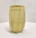 Vaso em vidro artístico soprado à mão, em tom âmbar-leitoso, com corpo ovalado ricamente texturizado por frisos verticais em forma de caneluras onduladas. A peça apresenta inclusões de pequenas bolhas de ar distribuídas de forma homogênea, característica de técnicas tradicionais de sopro e manipulação manual. O relevo profundo cria jogo de luz e sombra que valoriza o volume e destaca o brilho suave da superfície.  Dimensões: 26x18 centímetros.
