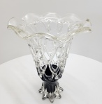 Imponente vaso decorativo em vidro artístico soprado, executado com a técnica de gotejamento estirado (droplet-pulled) formando uma estrutura reticulada em forma de trama entrelaçada, típica do trabalho manual de estúdio. A peça apresenta corpo vazado em vidro totalmente transparente, com aplicação de vidro negro no pé  criando um contraste escultural marcante entre a leveza da parte superior e a base sólida, de linhas onduladas. dimensões:38x26 centímetros.
