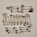 Conjunto formado por 30 colheres colecionáveis, todas em prata de lei, sendo a maioria com origem do México e do Peru. As colheres exibem decoração típica da ourivesaria desses países, com cabos ornados por brasões, motivos regionais, figuras tradicionais e referências turísticas gravadas. Os acabamentos incluem hastes trabalhadas, aplicações figurativas e bowls lisos ou levemente texturizados, preservando a pátina natural do tempo. Peso: 212 gramas