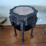 Mesa oriental entalhada, início a meados do século XX, executada em madeira maciça com rica talha floral em toda a estrutura. O tampo octogonal em mármore rosa contrasta elegantemente com o entalhe profundo, composto por flores de ameixeira, volutas e frisos de contas. As pernas, igualmente trabalhadas, apresentam motivos vegetais e terminações em garras estilizadas. Peça de elaboração artesanal, típica da produção sino-indonésia.Dimensões:81x57x57 centímetros.