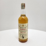 DEWARS  WHITE LABELFinest Scotch Whisky  1 Litre  43% volJohn Dewar & Sons Ltd., Perth  Scotland Garrafa vintage do tradicional Dewars White Label, em sua apresentação clássica de 1 litro, com graduação alcoólica 43% vol (formato superior ao padrão atual, que é 40%).Rótulo frontal no estilo antigo, destacando as medalhas históricas de premiação e o brasão da casa. A garrafa mantém a tampa e o lacre originais, com leve desgaste natural do tempo, sem prejuízo à integridade do conteúdo. Versão produzida pela John Dewar & Sons Ltd., Perth, Scotland, muito anterior à padronização moderna da marca