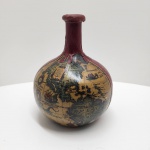 GARRAFA GLOBO CARTOGRÁFICO  ITÁLIA Brandy Italiano  Década de 19701990  Lacrada Garrafa decorativa italiana em formato de globo terrestre, revestida com mapa cartográfico em estilo renascentista, com verniz protetor. Acabamento superior e inferior em material sintético texturizado na cor vinho. Tampa original em cortiça lacrada com cera vermelha, apresentando desgaste natural do tempo, mas mantendo a selagem original. Modelo produzido por destilarias italianas entre as décadas de 70 e 90, utilizado principalmente para envase de brandy italiano,