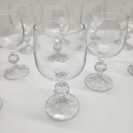 Conjunto composto por 12 taças para vinho branco em cristal transparente, todas com corpo liso e haste ornamentada por esfera facetada, detalhe clássico de lapidação decorativa. Base com leve faceteamento radial, produzindo discreto brilho sob a luz. Dimensões:15x7centímetros.