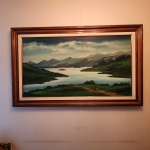 Alberto Matera (19392016), óleo sobre tela, intitulado Contemplando o Infinito, datado de 1987. Paisagem serena e profundamente atmosférica do artista brasileiro Alberto Matera, reconhecido por suas composições bucólicas de montanhas, lagos e horizontes amplos. Nesta obra, intitulada Contemplando o Infinito, Matera apresenta um panorama de montanhas azuladas ao fundo, com espelho dágua sinuoso e áreas de vegetação verde intensa, acompanhadas de pequenas figuras humanas que reforçam a escala monumental da natureza. Dimensões:0,80x1,20