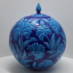 Imponente vaso esférico turco, produzido em cerâmica artesanal de influência Iznik / Anatólia, região reconhecida por sua tradição na cerâmica esmaltada de alta qualidade. A peça apresenta corpo perfeitamente arredondado, decorado com exuberantes motivos florais em relevo, trabalhados em estilo clássico otomano, com folhas e flores alongadas.A paleta cromática é composta por um fundo azul cobalto profundo, contrastado por aplicações em turquesa vivo, resultando em forte impacto visual e destacando o trabalho em baixo-relevo. A tampa segue o mesmo padrão decorativo e é finalizada por um elegante pináculo estriado.Dimensões:70x60 centímetros.