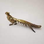 Escultura decorativa representando faisão de cauda longa, executada em bronze, apresentando modelagem detalhada das penas, porte elegante e cauda alongada de grande efeito visual. Trabalho típico da produção decorativa oriental do século XX. Dimensões: 13x32x11 centímetros.