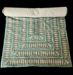 Belíssima tapeçaria de chão Madalena Colaço, reconhecida artista portuguesa do século XX, cuja produção se destaca pela fusão entre tradição artesanal e design geométrico moderno.A peça apresenta composição retangular em tons de verde, bege e preto, com padrões rítmicos e simétricos característicos da artista, evocando o equilíbrio entre estrutura e movimento.Executada em tear manual, utilizando fibras naturais, a obra revela o domínio técnico e a sofisticação estética típicas do atelier de Madalena Colaço, pioneira no desenvolvimento da tapeçaria contemporânea em Portugal. Dimensões: 3,53x1,31.